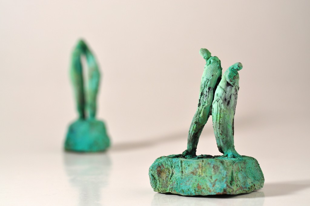 Bronzefigurer der støtter - ryg mod ryg.