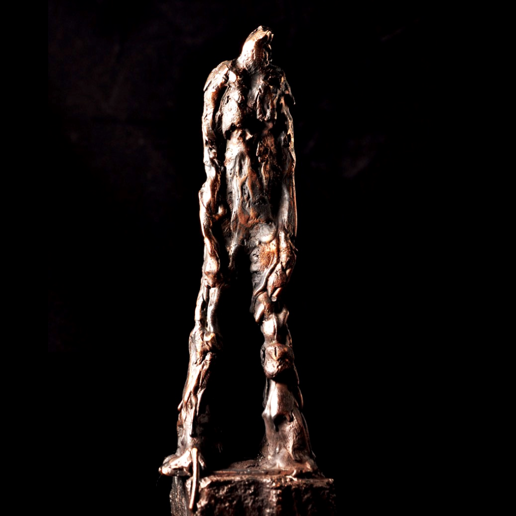 Grounded - bronzefigur med markant udtryk.